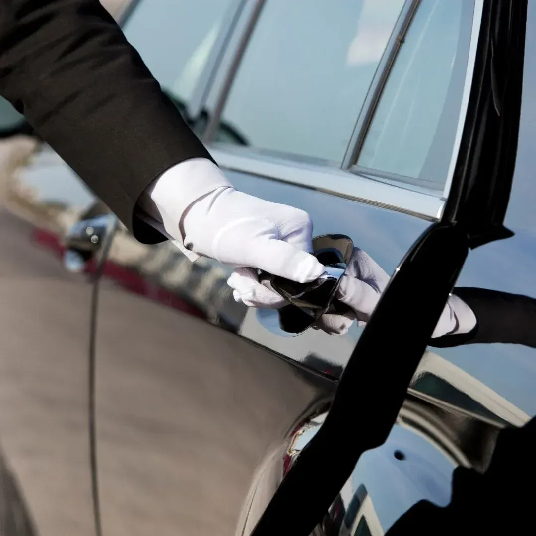 Professional chauffeur opening the rear door of a luxury vehicle for an executive car service in Cleveland